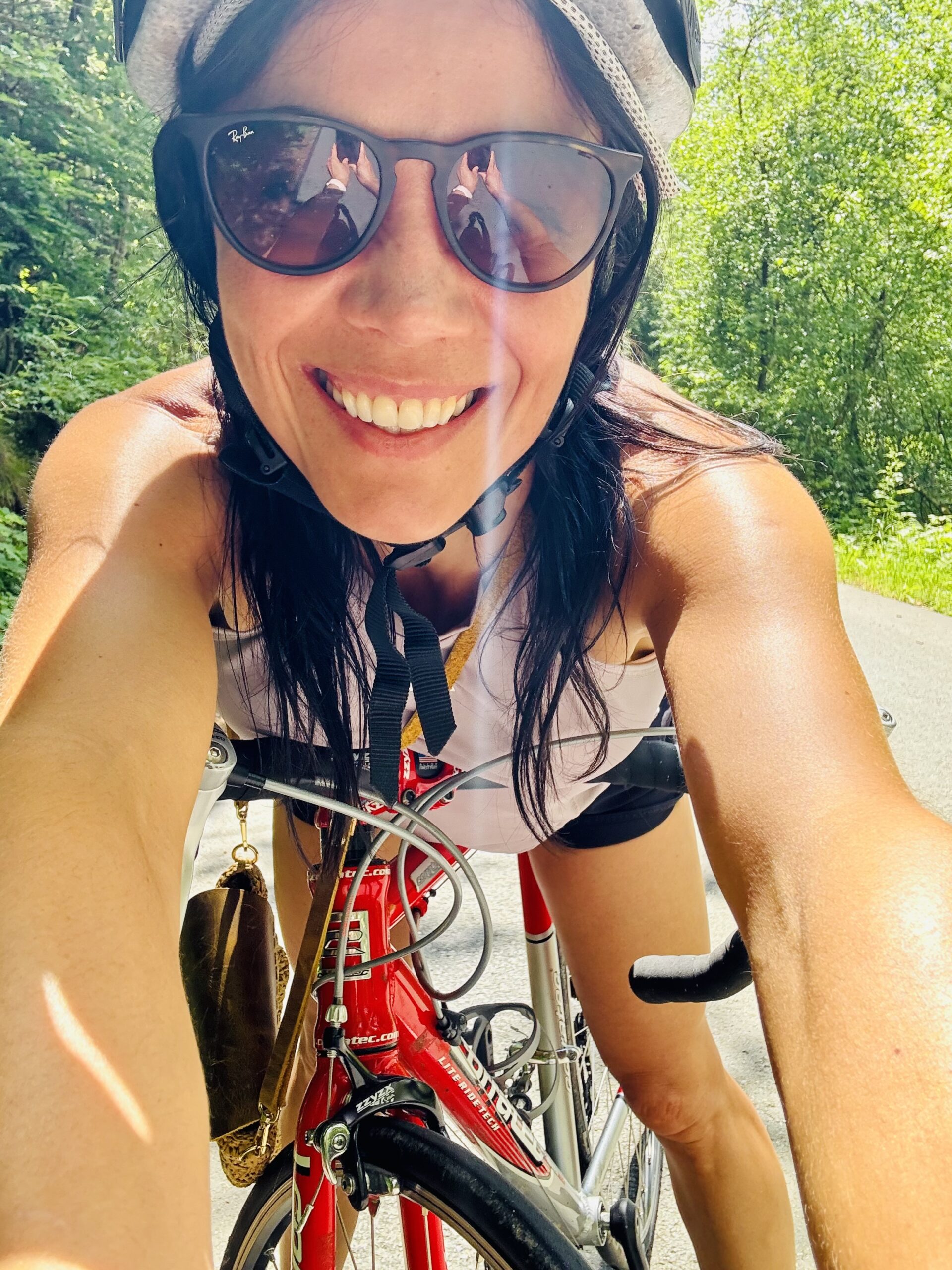 Frau mit Fahrradhelm macht Selfie im Wald