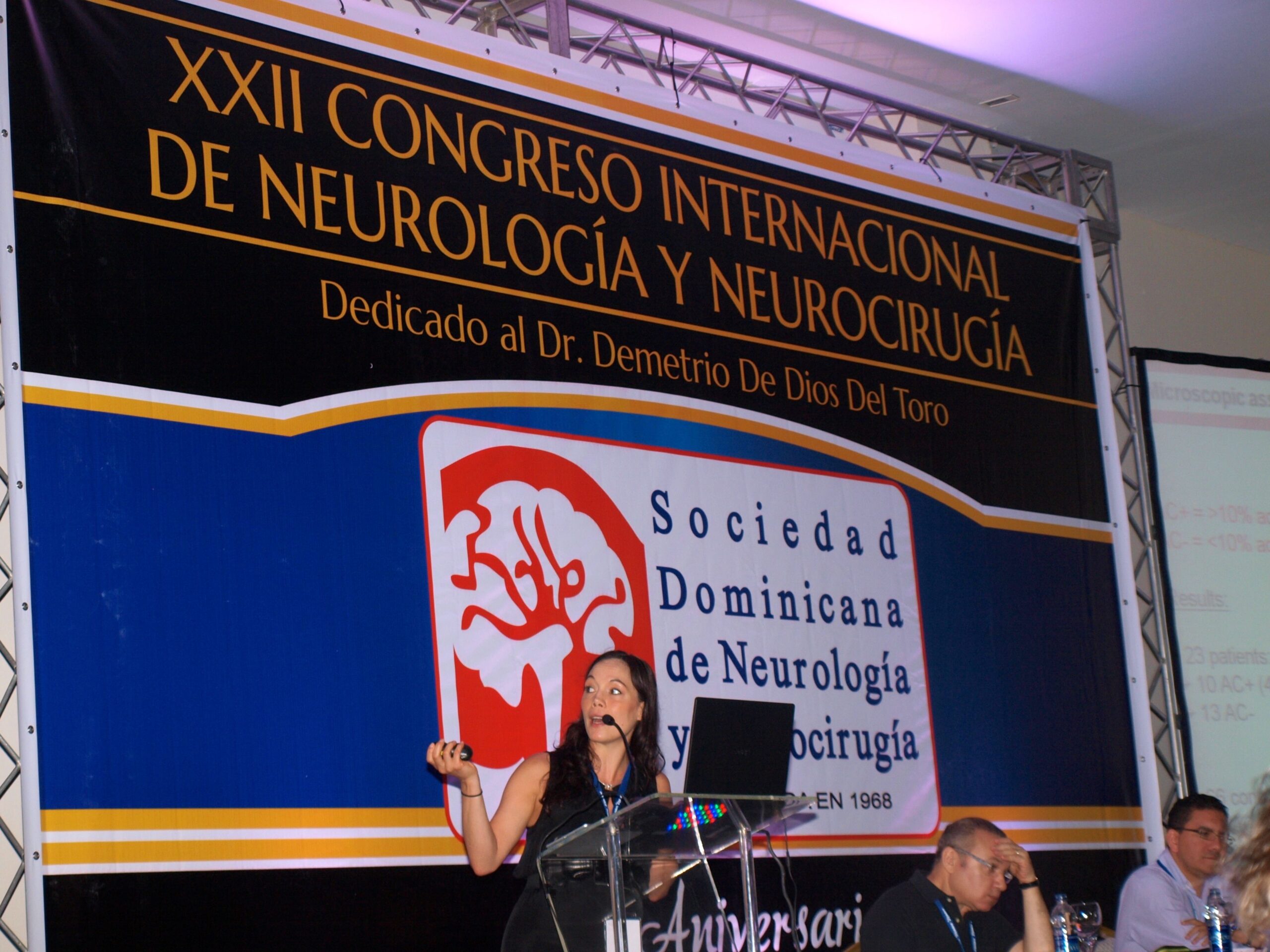 Rednerin auf Neurologie-Kongress vor großem Banner